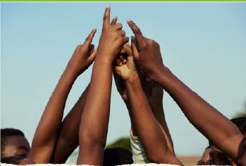 Hands raised and joined together against the sky