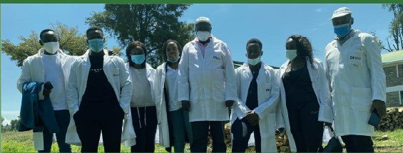 A team in white coats standing together outdoors