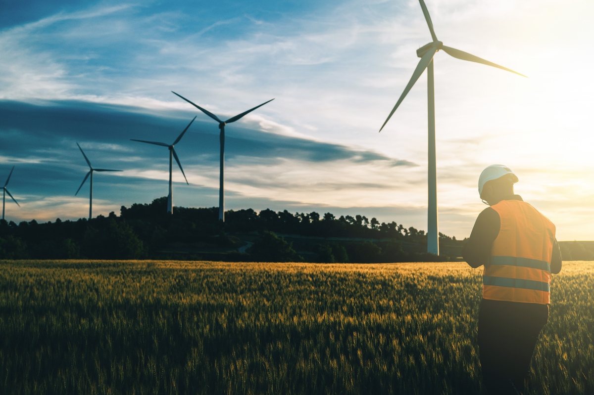 Wind turbines at sunset above farmland
